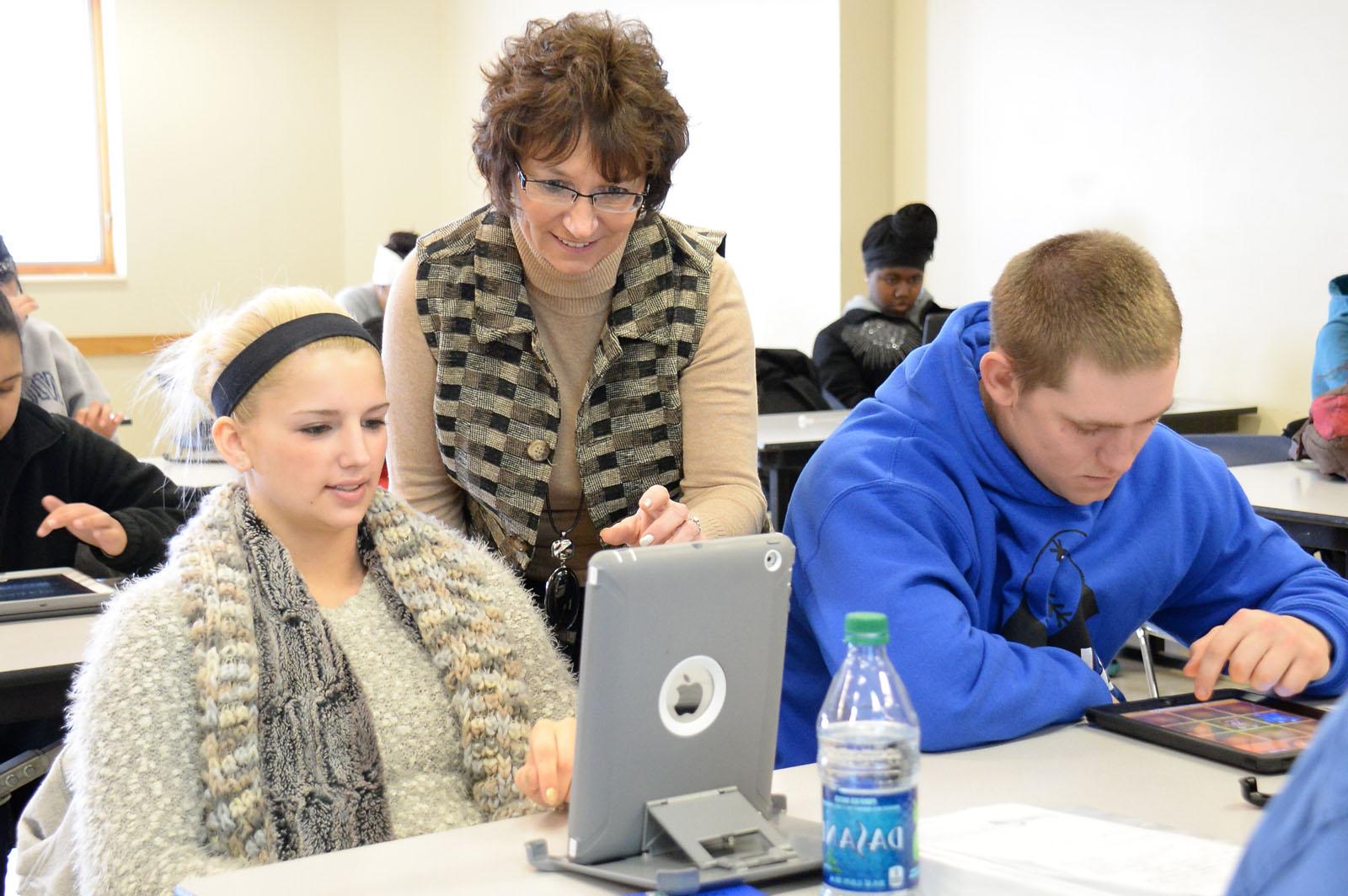 A female student showing the professor something on her tablet